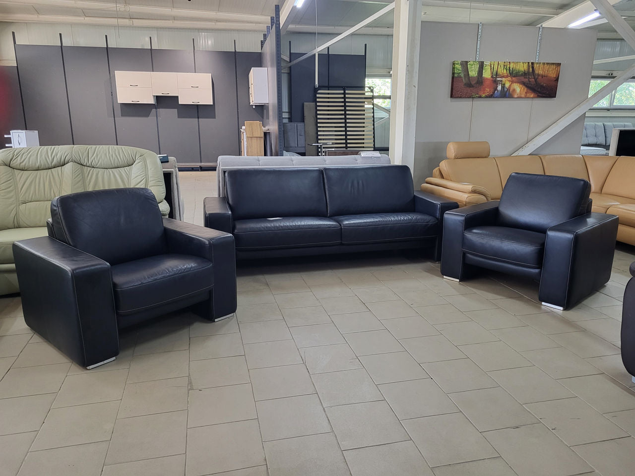 Set canapea și două fotolii din piele bleumarin în showroom MobiHaus